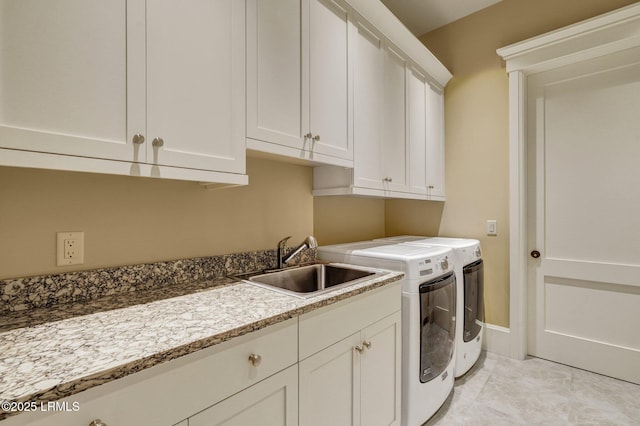 laundry area with cabinets, washer and dryer, and sink