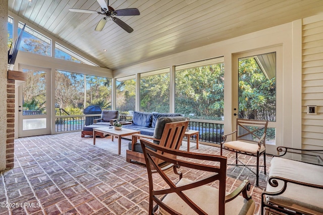 sunroom / solarium featuring a wealth of natural light, wooden ceiling, ceiling fan, and vaulted ceiling