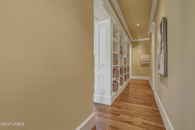 corridor featuring ornamental molding and light hardwood / wood-style floors