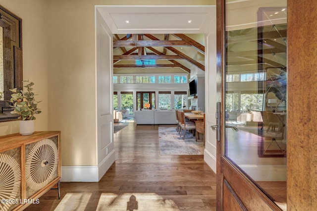 hallway featuring hardwood / wood-style floors, beam ceiling, and high vaulted ceiling