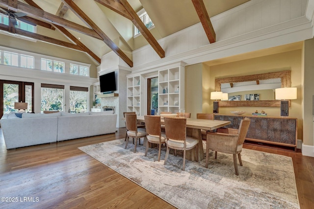 dining area featuring beam ceiling, hardwood / wood-style flooring, high vaulted ceiling, and french doors