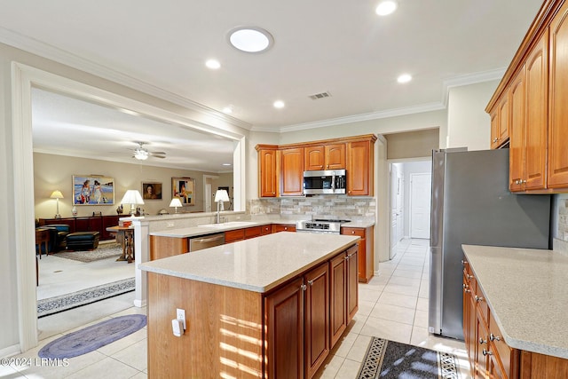 kitchen featuring light tile patterned floors, ornamental molding, kitchen peninsula, a kitchen island, and stainless steel appliances