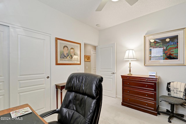 home office with ceiling fan, light colored carpet, and a textured ceiling