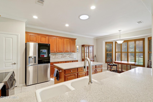 kitchen featuring pendant lighting, sink, stainless steel appliances, ornamental molding, and a kitchen island