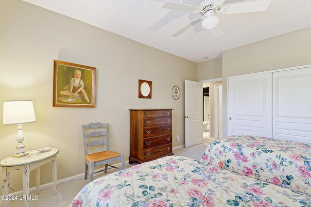 bedroom featuring light carpet, a textured ceiling, a closet, and ceiling fan