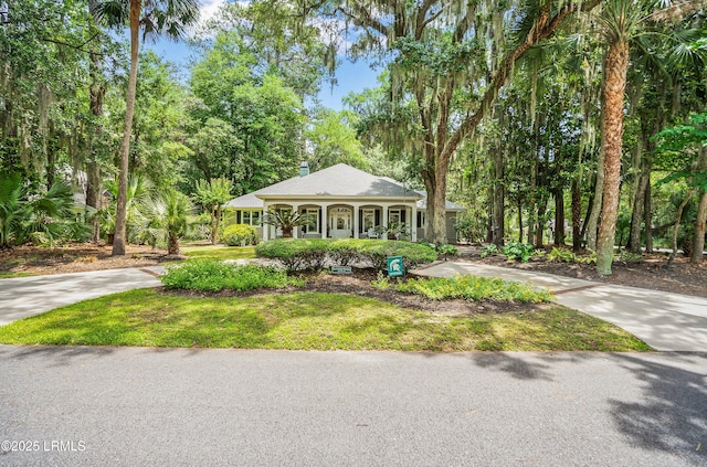 1 Wild Magnolia Ct, Okatie, SC 29909 - view of front of home with concrete driveway, a porch, a chimney, and a front lawn