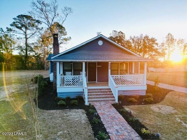 bungalow featuring a shingled roof and a porch