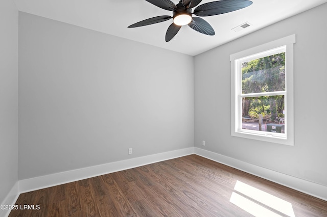 unfurnished room with a ceiling fan, baseboards, visible vents, and dark wood finished floors