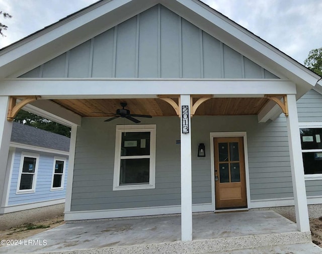 view of exterior entry with ceiling fan and covered porch