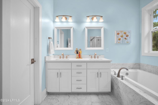 bathroom with vanity and tiled bath