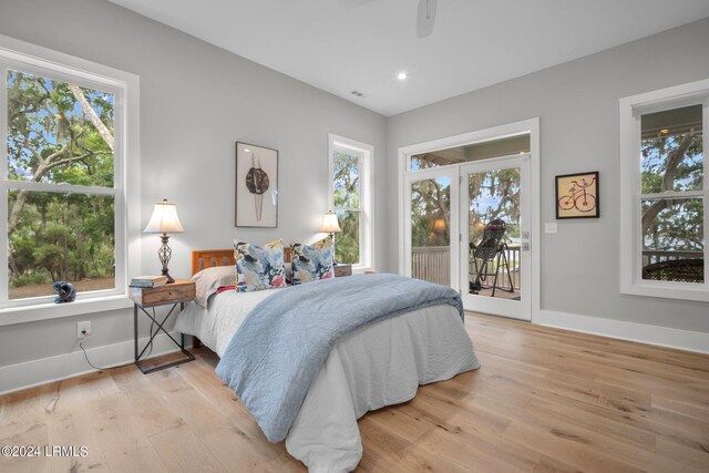 bedroom featuring multiple windows, light wood-type flooring, access to exterior, and ceiling fan