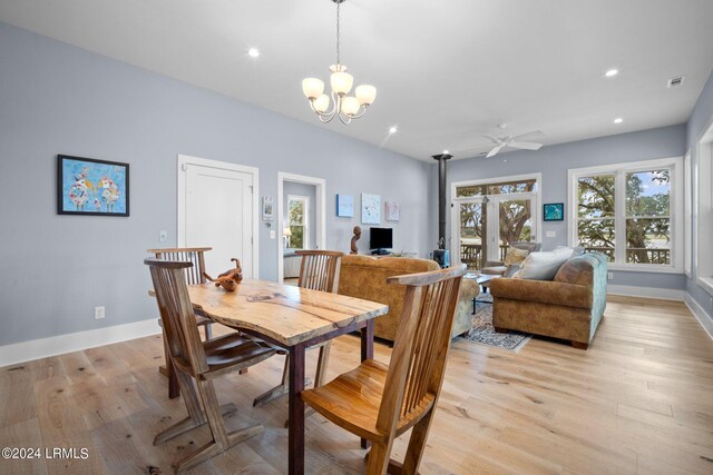 dining area featuring ceiling fan with notable chandelier and light hardwood / wood-style floors