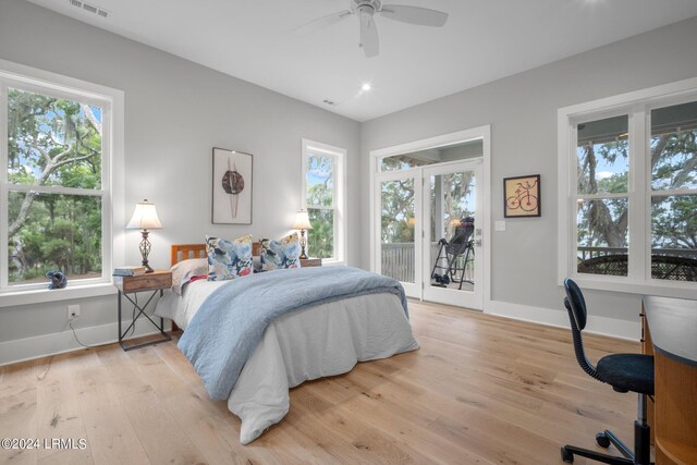 bedroom featuring ceiling fan, light wood-type flooring, multiple windows, and access to outside