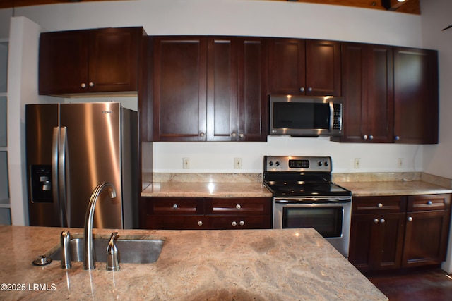 kitchen with light stone counters, appliances with stainless steel finishes, and sink