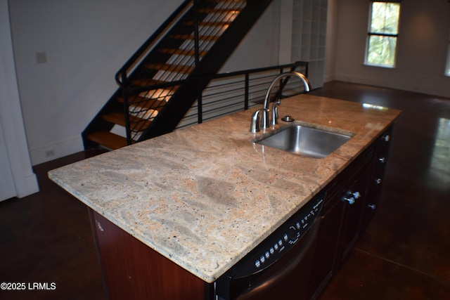 kitchen featuring an island with sink, black dishwasher, sink, light stone countertops, and dark brown cabinets