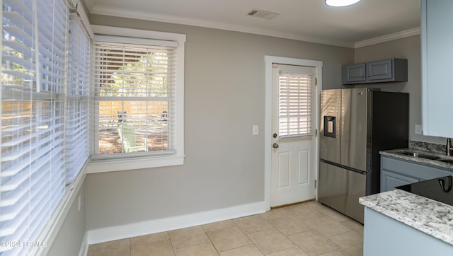 kitchen with stainless steel refrigerator with ice dispenser, light tile patterned flooring, sink, crown molding, and gray cabinets