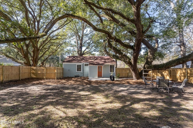 rear view of property featuring an outdoor structure