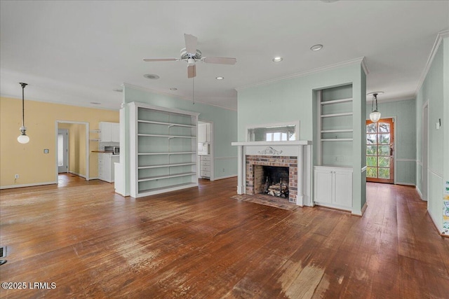 10 Broomfield Ln, Beaufort, SC 29907 - unfurnished living room with ornamental molding, ceiling fan, wood-type flooring, a brick fireplace, and baseboards