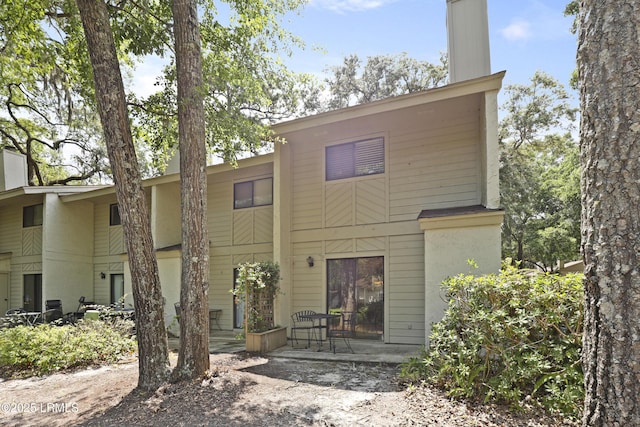 96 Mathews Dr Unit 145, Hilton Head Island, SC 29926 - rear view of property with a patio and a chimney