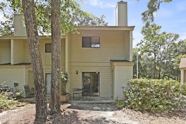 96 Mathews Dr Unit 145, Hilton Head Island, SC 29926 - view of front of house with a patio area and a chimney