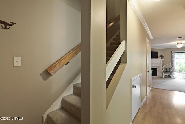 96 Mathews Dr Unit 145, Hilton Head Island, SC 29926 - stairs featuring ornamental molding, wood finished floors, and a fireplace