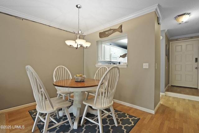 96 Mathews Dr Unit 145, Hilton Head Island, SC 29926 - dining area with crown molding, light wood-style flooring, and a chandelier