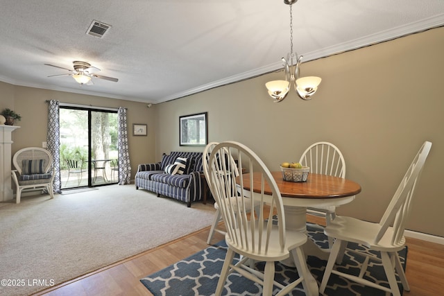 96 Mathews Dr Unit 145, Hilton Head Island, SC 29926 - dining space featuring crown molding, a chandelier, a ceiling fan, and wood finished floors