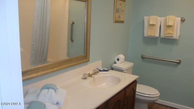 bathroom featuring walk in shower, vanity, and toilet