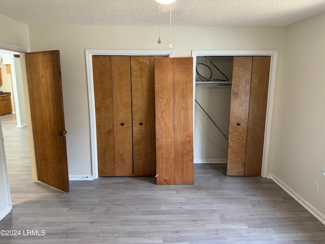 unfurnished bedroom featuring a textured ceiling and light hardwood / wood-style flooring