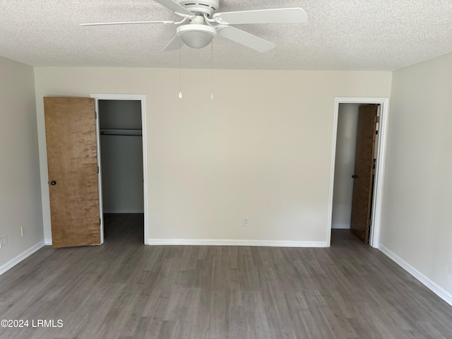 unfurnished bedroom featuring dark hardwood / wood-style flooring, a textured ceiling, ceiling fan, and a closet