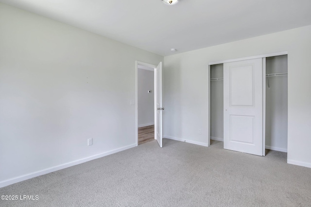 unfurnished bedroom with carpet floors, baseboards, and a closet