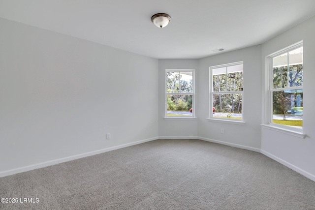 spare room with visible vents, baseboards, and carpet flooring