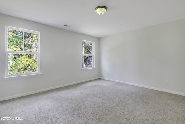 carpeted empty room featuring visible vents and baseboards