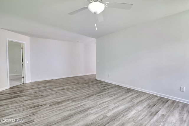 unfurnished room featuring ceiling fan, baseboards, and wood finished floors