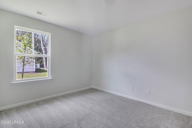 unfurnished room with carpet floors, visible vents, and baseboards