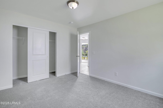 unfurnished bedroom with carpet floors, a closet, and baseboards