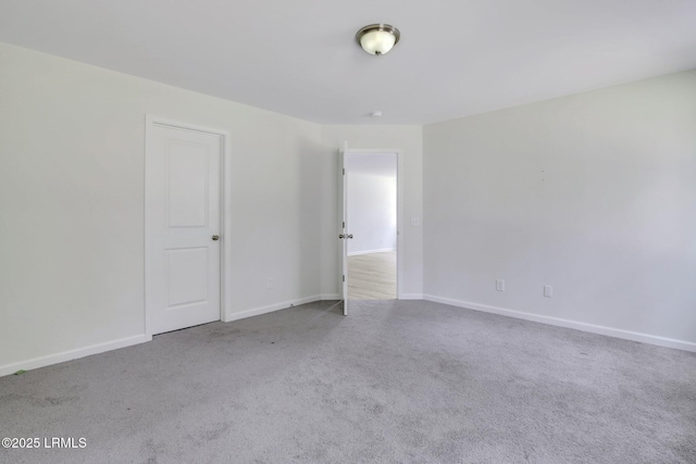 carpeted empty room featuring baseboards