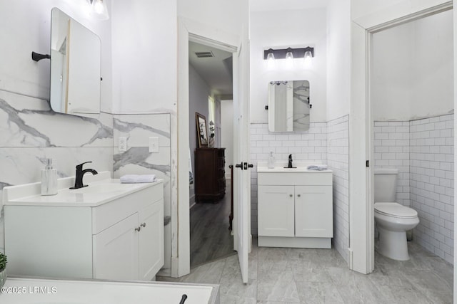 100 Drayton Dr, Ridgeland, SC 29936 - bathroom with tile walls, two vanities, and wainscoting