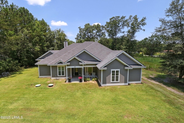 100 Drayton Dr, Ridgeland, SC 29936 - view of front of home with a front lawn, a shingled roof, a chimney, and a patio area