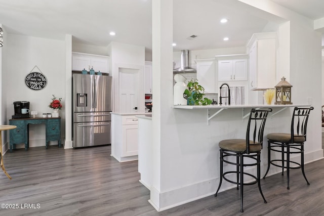 100 Drayton Dr, Ridgeland, SC 29936 - kitchen with stainless steel fridge with ice dispenser, wall chimney exhaust hood, white cabinetry, dark wood-style flooring, and recessed lighting