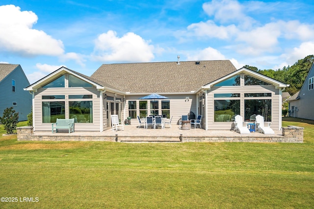 back of house featuring a patio area, a shingled roof, and a lawn