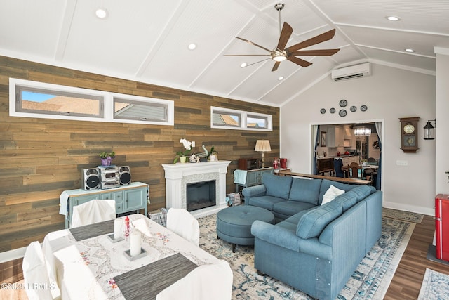 living area featuring wood finished floors, a ceiling fan, wooden walls, a wall mounted AC, and recessed lighting