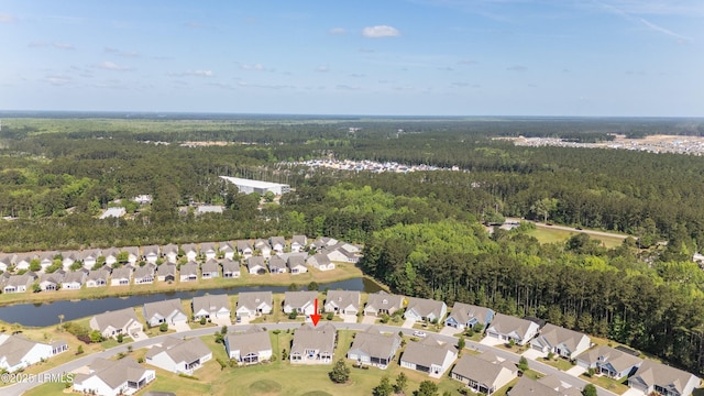 drone / aerial view with a wooded view, a water view, and a residential view