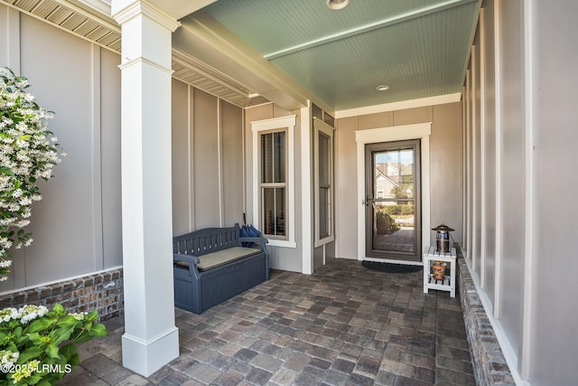 property entrance featuring covered porch and board and batten siding