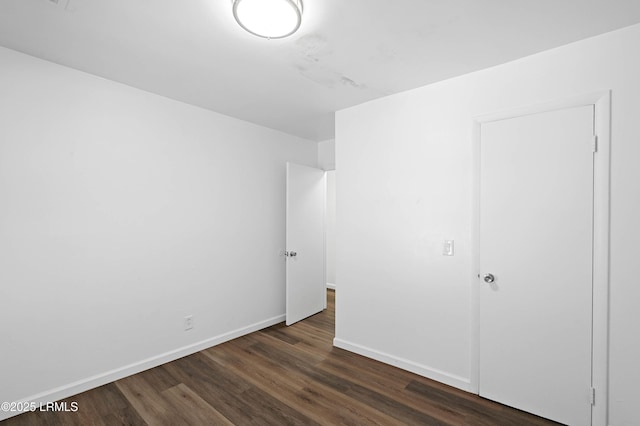 unfurnished bedroom with dark wood-style floors and baseboards