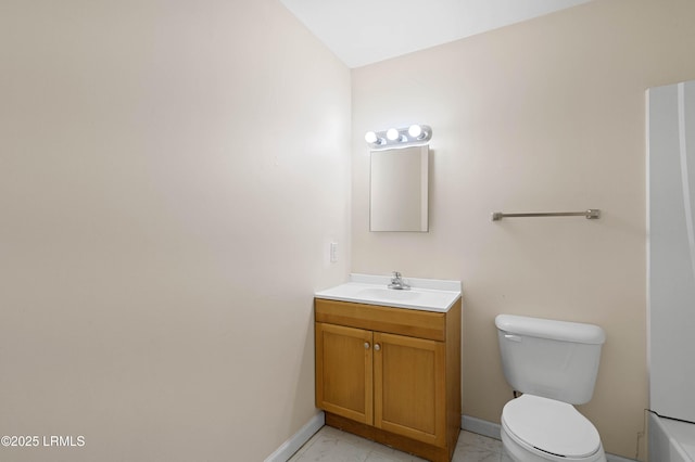 bathroom with marble finish floor, toilet, vanity, and baseboards