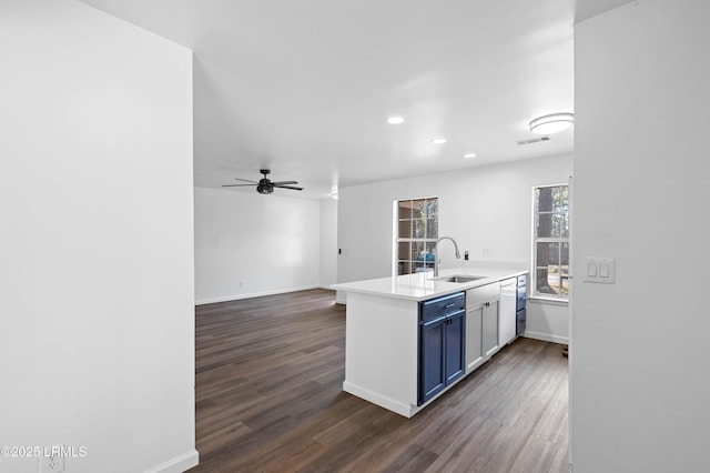 kitchen with a peninsula, visible vents, dark wood-type flooring, and a sink