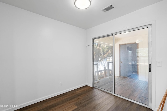 empty room featuring dark wood finished floors, baseboards, and visible vents