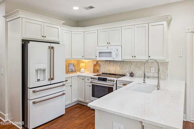 8 Chechessee Cir, Okatie, SC 29909 - kitchen with white appliances, a peninsula, visible vents, decorative backsplash, and a sink