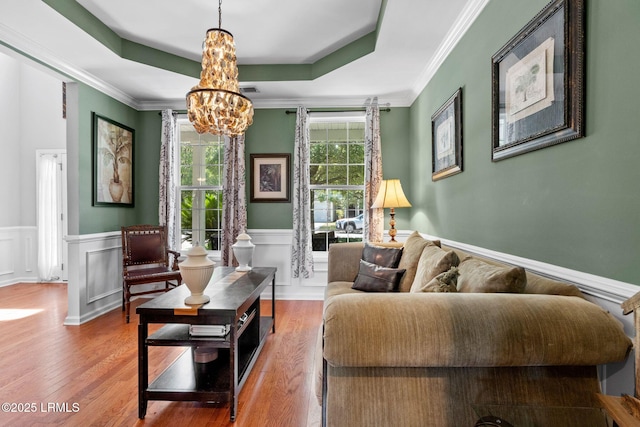 176 Pickett Mill Blvd, Bluffton, SC 29909 - living area featuring a chandelier, wood finished floors, wainscoting, a raised ceiling, and crown molding